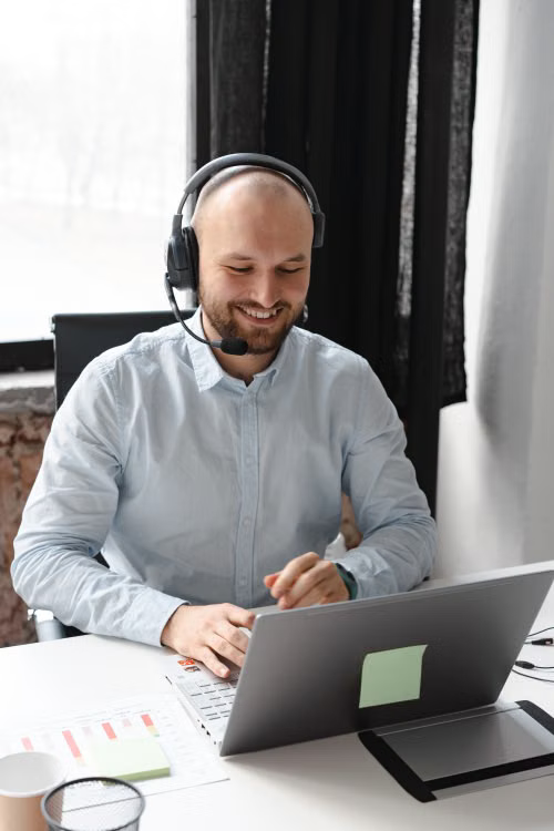 Support professional in a headset smiling while working at a home desk